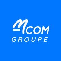 M COM